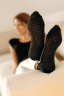 Frau trägt Yoga Socks und liegt auf dem Sofa
