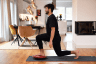 Mann macht Übungen auf dem Balance Board Plus